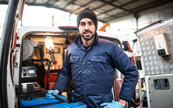 A business owner standing in front of his work truck