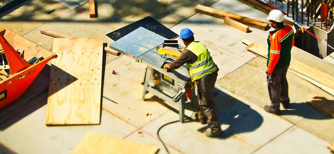 A carpenter cutting wood with a table saw