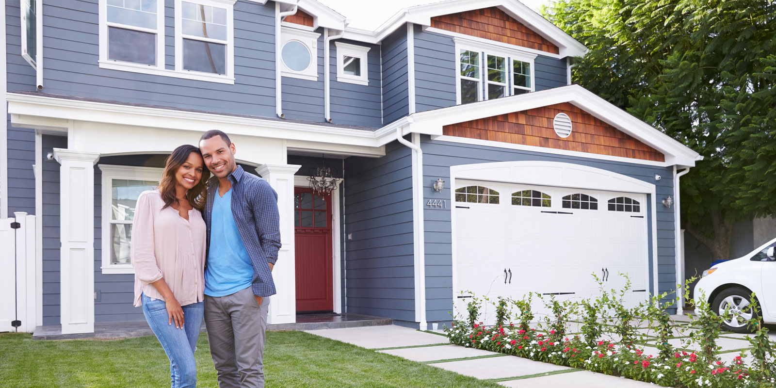 happy couple standing outside of their home